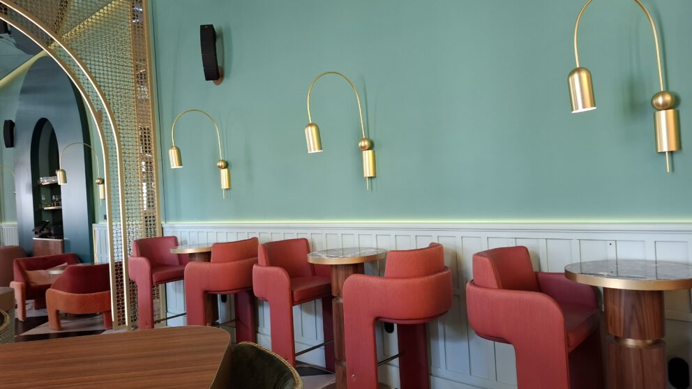 Stylish bar seating with pink stools and brass lighting at the W Budapest