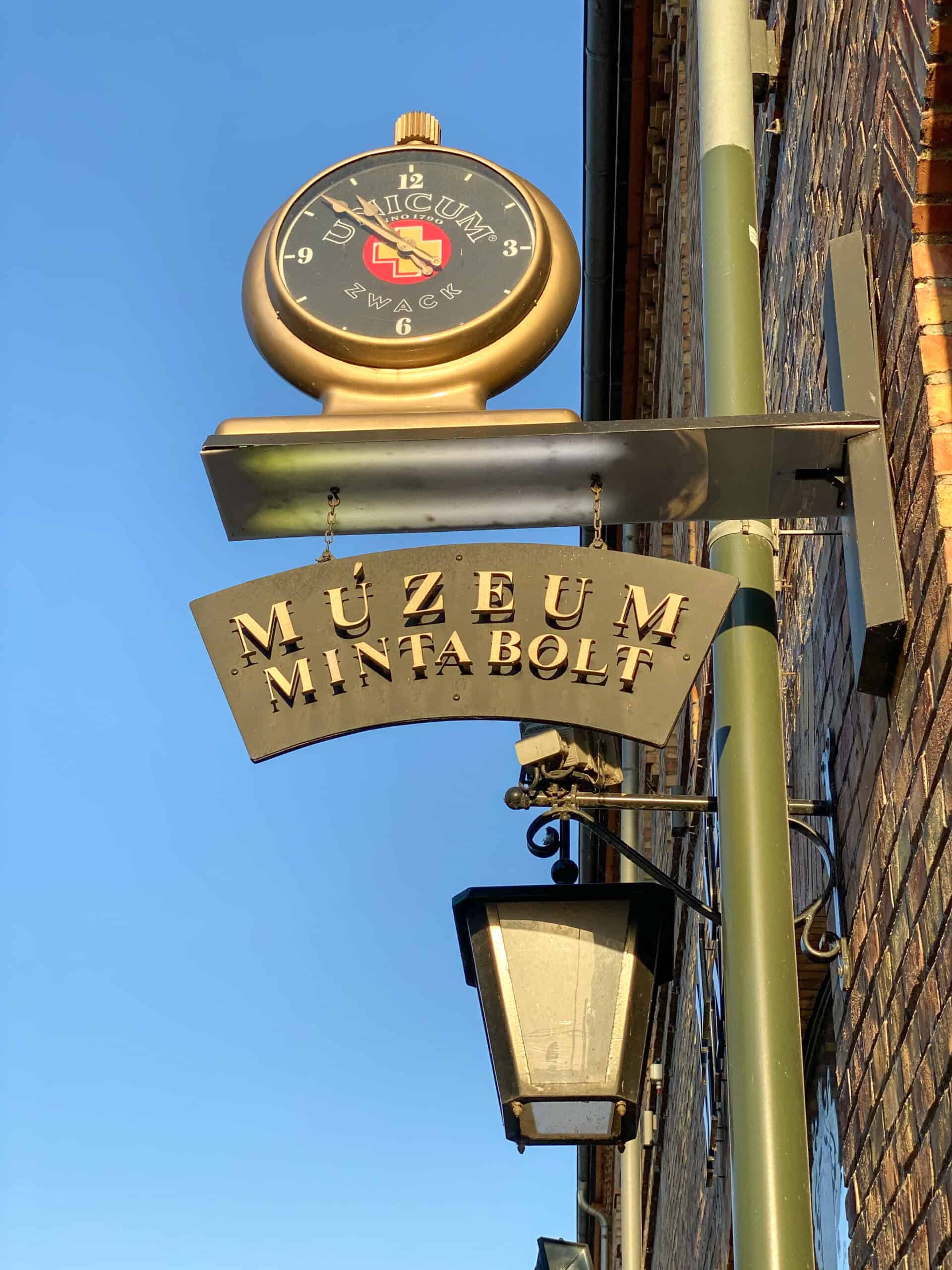 An antique clock-style sign for the Unicum Museum and Shop